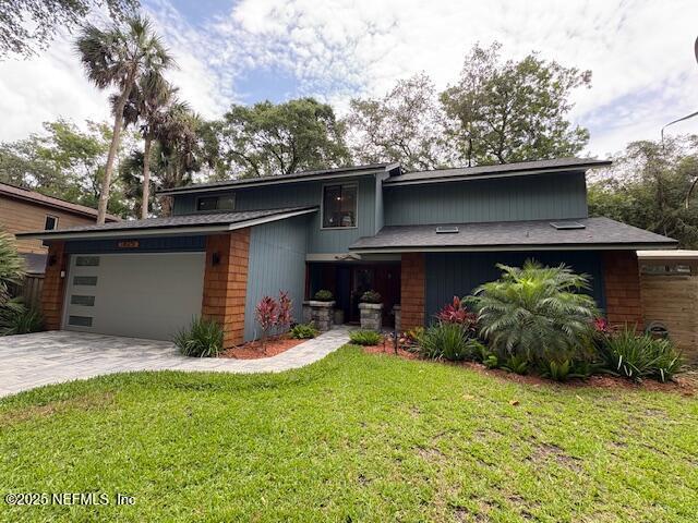 1825 Hickory Ln, Atlantic Beach, FL 32233 - mid-century inspired home with an attached garage, driveway, and a front lawn