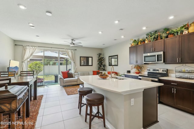 312 Anthony Dr, Jacksonville, FL 32218 - kitchen featuring ceiling fan, a kitchen bar, a sink, light countertops, and stainless steel microwave