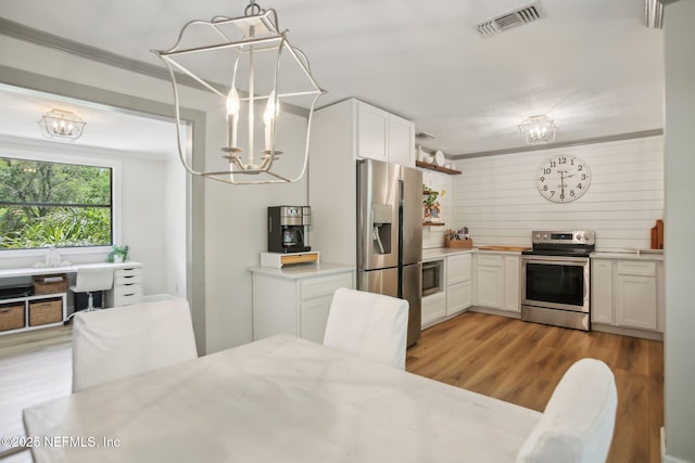 4068 Scenic Dr, Middleburg, FL 32068 - kitchen with a notable chandelier, stainless steel appliances, light countertops, white cabinetry, and visible vents