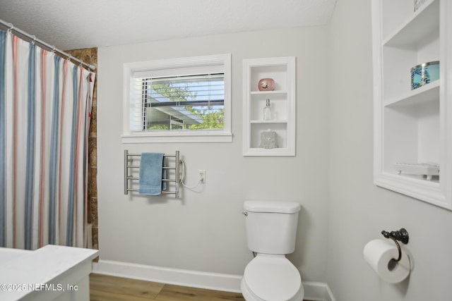 4068 Scenic Dr, Middleburg, FL 32068 - bathroom with wood finished floors, toilet, baseboards, and a shower with curtain