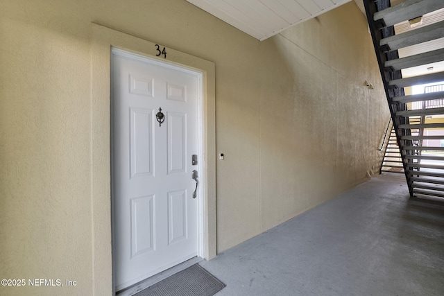 doorway to property featuring stucco siding