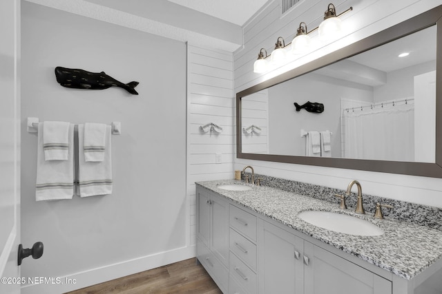 full bath featuring wood finished floors, baseboards, visible vents, and a sink