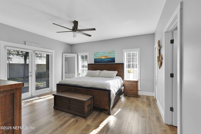 bedroom with light wood finished floors, ceiling fan, access to exterior, baseboards, and a textured ceiling