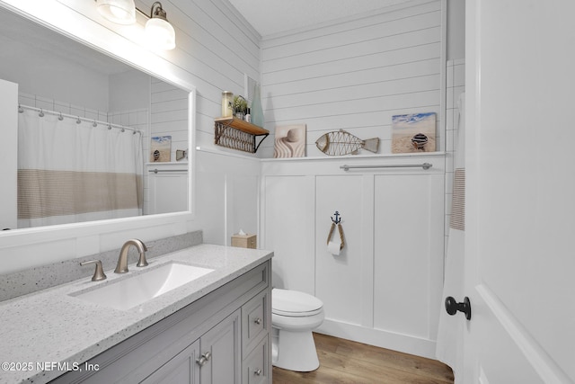 full bathroom featuring toilet, vanity, curtained shower, and wood finished floors