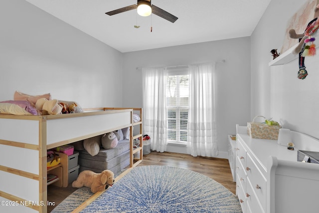 bedroom with wood finished floors, a ceiling fan, and baseboards