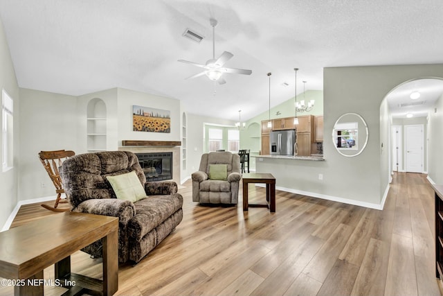 2925 Bradford St, Saint Augustine, FL 32084 - living area featuring light wood finished floors, vaulted ceiling, visible vents, a ceiling fan, and a glass covered fireplace