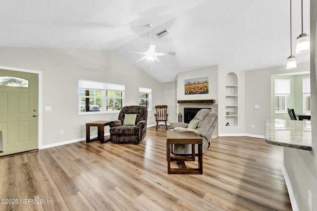 2925 Bradford St, Saint Augustine, FL 32084 - living area featuring vaulted ceiling, visible vents, light wood-type flooring, a fireplace, and built in features
