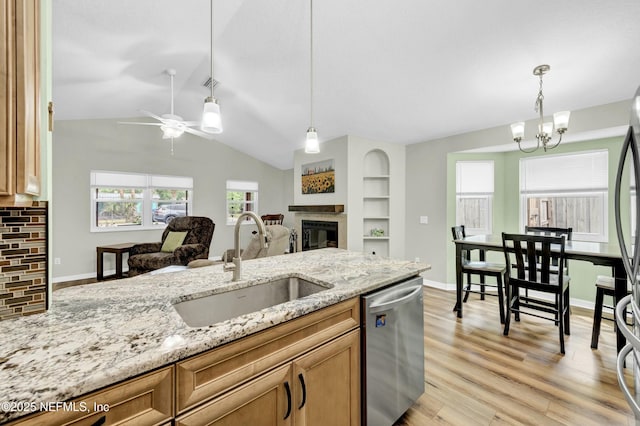 2925 Bradford St, Saint Augustine, FL 32084 - kitchen with a sink, a glass covered fireplace, ceiling fan with notable chandelier, light stone counters, and appliances with stainless steel finishes