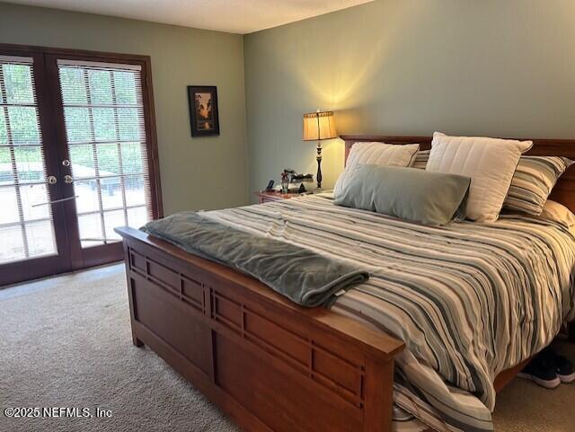 12186 Dividing Oaks Trl W, Jacksonville, FL 32223 - bedroom with light carpet, french doors, and access to outside