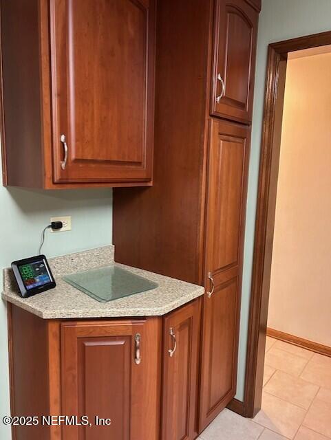 12186 Dividing Oaks Trl W, Jacksonville, FL 32223 - kitchen with light countertops, baseboards, light tile patterned floors, and brown cabinets