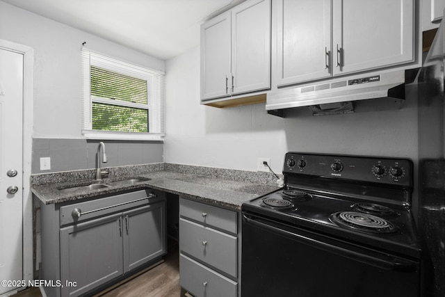 1585 W 31st St, Jacksonville, FL 32209 - kitchen with a sink, black electric range oven, wood finished floors, gray cabinets, and under cabinet range hood