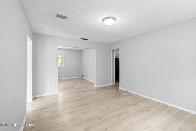 1585 W 31st St, Jacksonville, FL 32209 - unfurnished room with baseboards, a textured ceiling, visible vents, and light wood-style floors