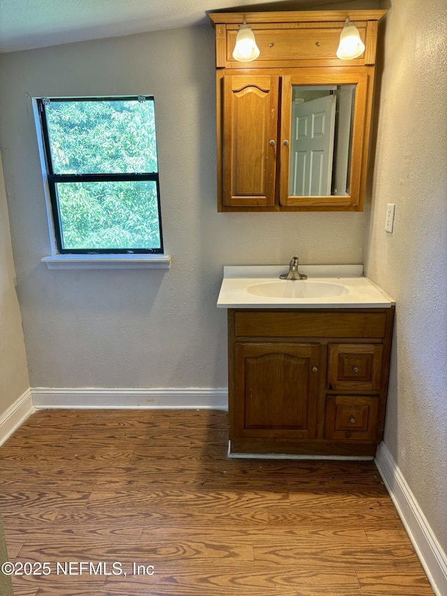 2027 W 12th St, Jacksonville, FL 32209 - bathroom featuring wood finished floors, vanity, and baseboards