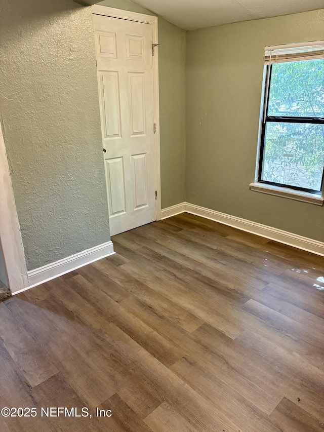 2027 W 12th St, Jacksonville, FL 32209 - unfurnished room with baseboards, a textured wall, and wood finished floors