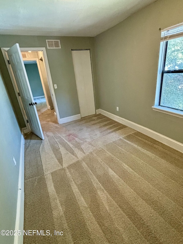 2027 W 12th St, Jacksonville, FL 32209 - unfurnished bedroom with baseboards, visible vents, carpet, and a closet