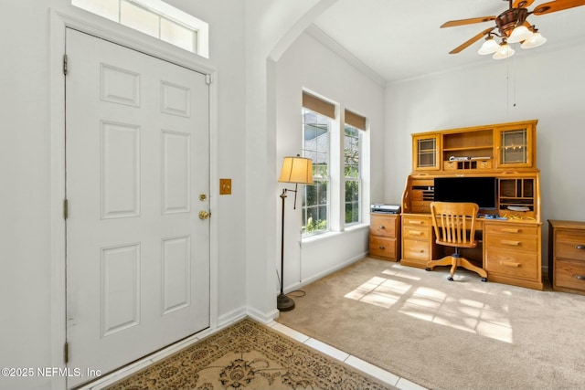 office space with arched walkways, baseboards, light colored carpet, a ceiling fan, and crown molding
