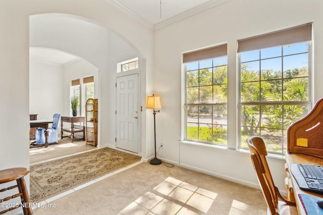 entryway with arched walkways, a healthy amount of sunlight, and carpet flooring