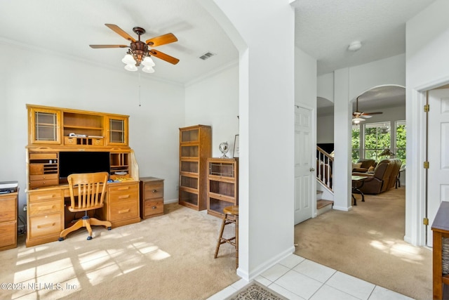 office space with arched walkways, visible vents, light colored carpet, ceiling fan, and crown molding