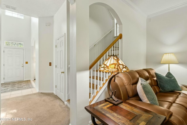 interior space with arched walkways, visible vents, tile patterned flooring, stairs, and crown molding