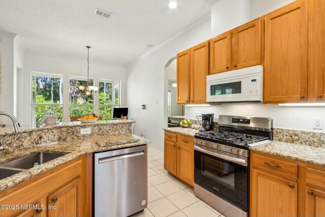 kitchen with stainless steel appliances, a sink, visible vents, ornamental molding, and light tile patterned floors