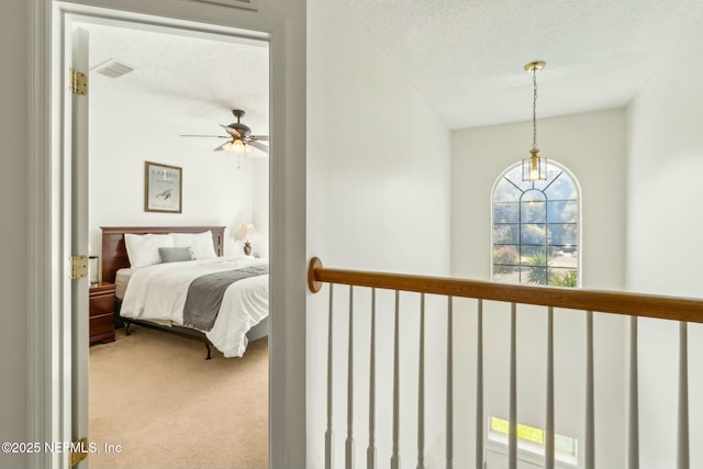 carpeted bedroom featuring a textured ceiling and visible vents