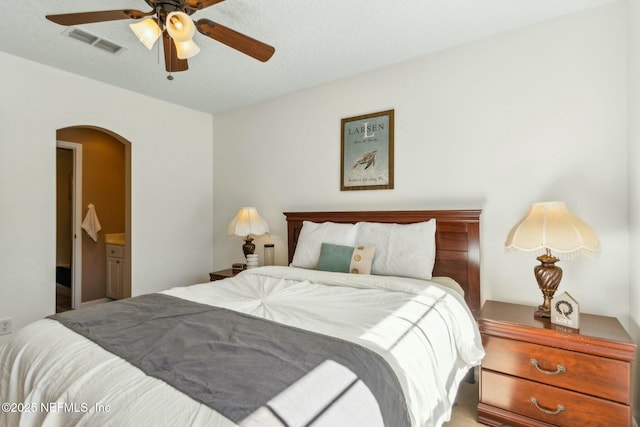bedroom featuring arched walkways, a ceiling fan, and visible vents
