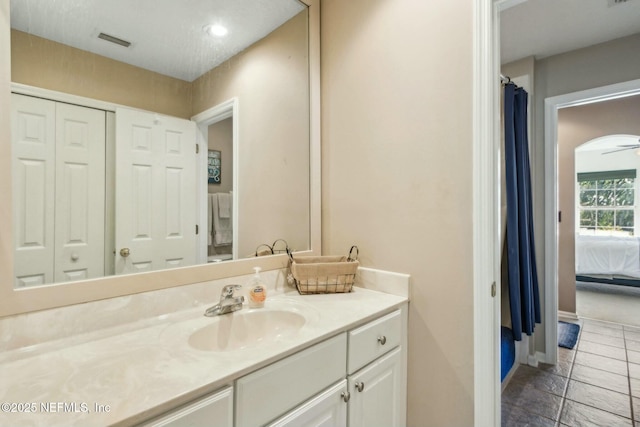 ensuite bathroom featuring ensuite bathroom, vanity, baseboards, tile patterned flooring, and visible vents