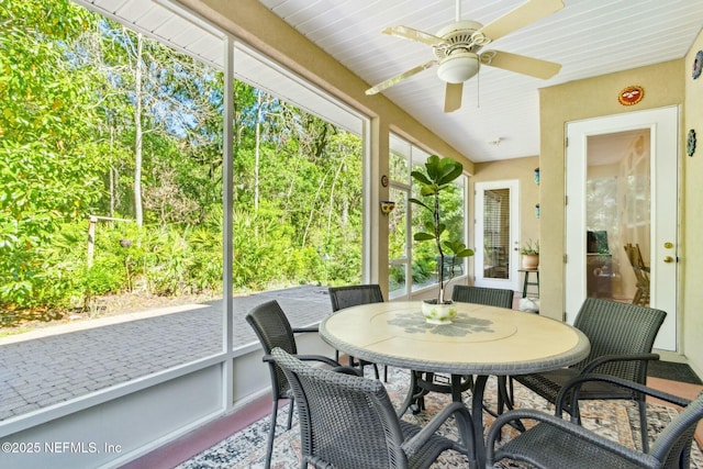 sunroom featuring a ceiling fan and outdoor dining space