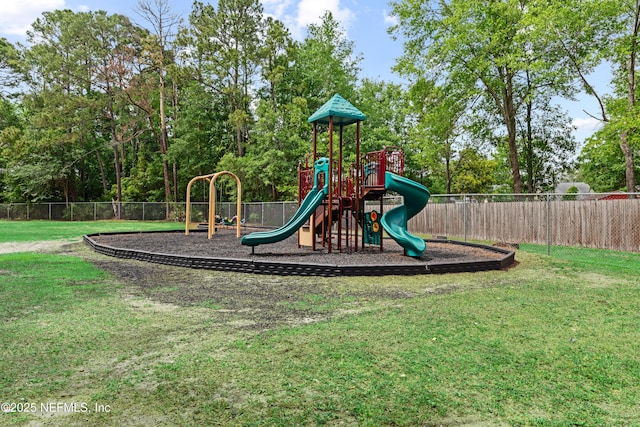 community play area with a lawn and fence