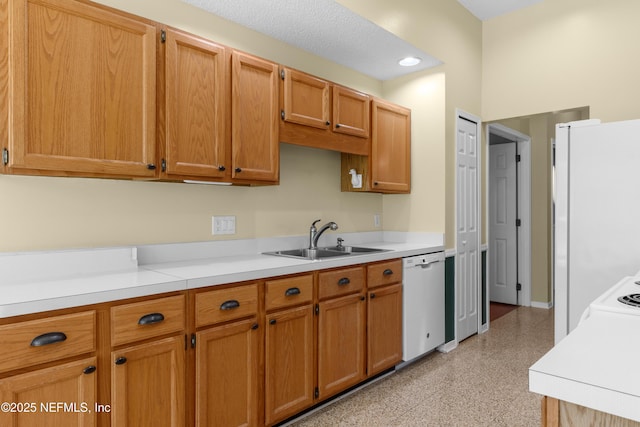 kitchen with white dishwasher, light countertops, baseboards, and a sink