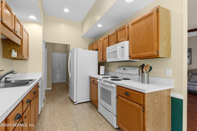 kitchen with white appliances, baseboards, a sink, and light countertops