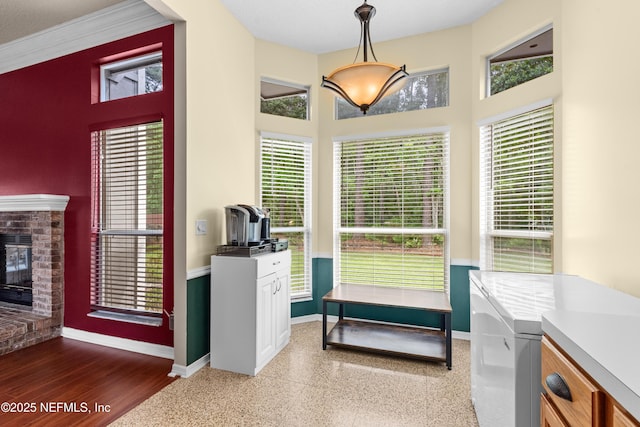 dining space with baseboards, a high ceiling, and a brick fireplace