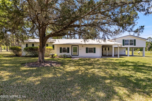 view of front of house featuring a carport, a front yard, and metal roof