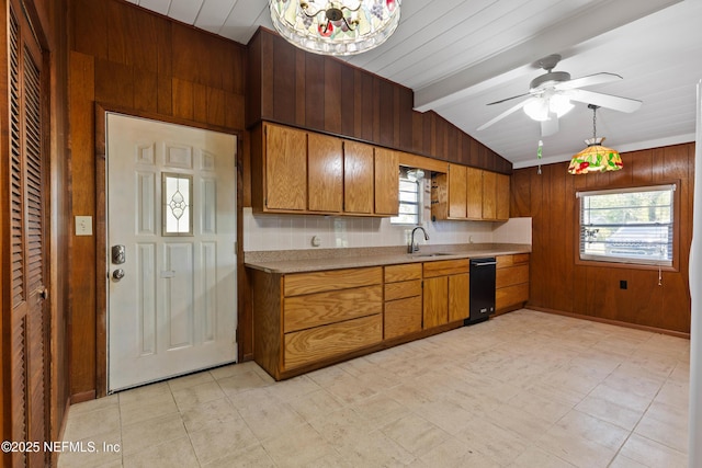 kitchen with light countertops, wood walls, lofted ceiling with beams, and a sink