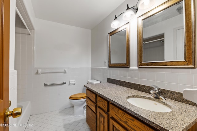 bathroom featuring wainscoting, vanity, tile walls, toilet, and tile patterned flooring