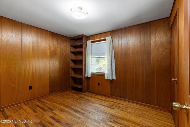 spare room with wood walls and wood finished floors