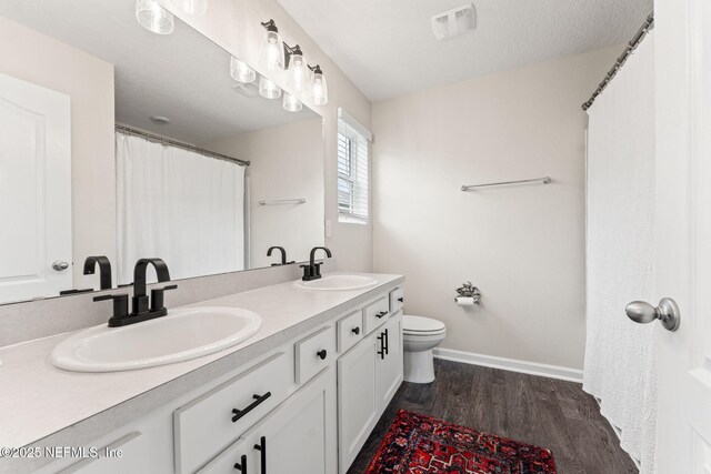 11476 Sheepshead Ln, Jacksonville, FL 32226 - full bath featuring toilet, wood finished floors, baseboards, and double vanity