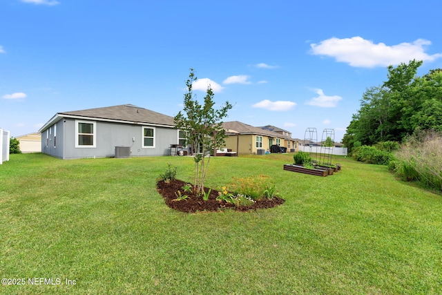 11476 Sheepshead Ln, Jacksonville, FL 32226 - view of green lawn featuring central air condition unit and a garden