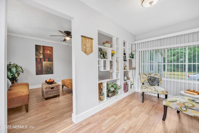 sitting room featuring built in features, ceiling fan, baseboards, and wood finished floors