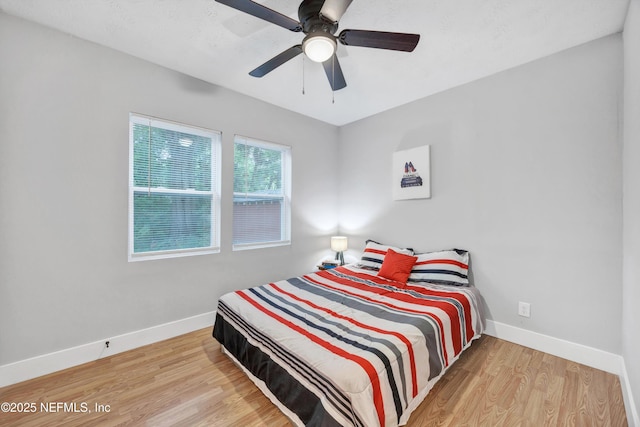 bedroom featuring baseboards, a ceiling fan, and wood finished floors