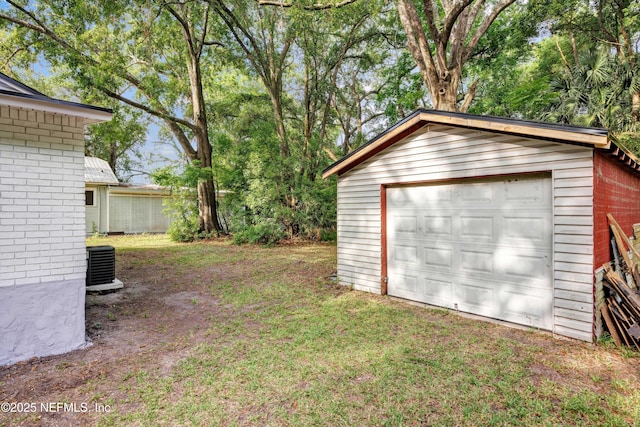 exterior space with a garage, an outbuilding, and cooling unit