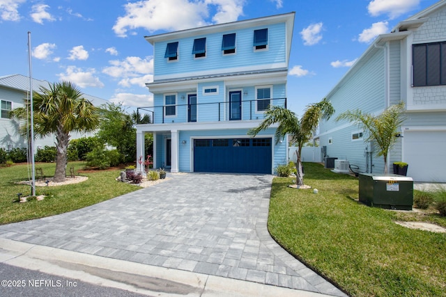 548 Sea Island Dr, Fernandina Beach, FL 32034 - beach home featuring a balcony, decorative driveway, a garage, and a front lawn