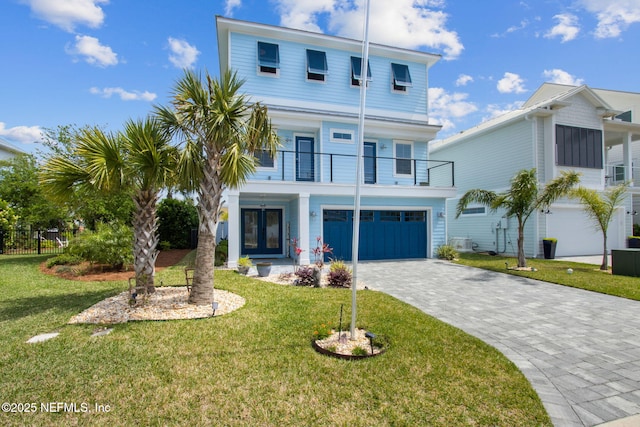 548 Sea Island Dr, Fernandina Beach, FL 32034 - view of front facade featuring a balcony, a garage, decorative driveway, and french doors
