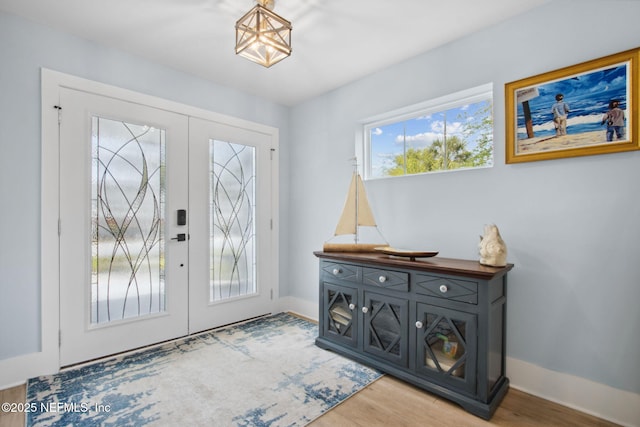 548 Sea Island Dr, Fernandina Beach, FL 32034 - foyer entrance with french doors, baseboards, and light wood-style floors