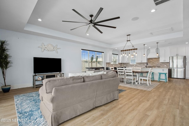 548 Sea Island Dr, Fernandina Beach, FL 32034 - living area with a raised ceiling, ceiling fan, light wood-style floors, recessed lighting, and baseboards