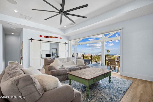 548 Sea Island Dr, Fernandina Beach, FL 32034 - living room featuring a barn door, a ceiling fan, recessed lighting, light wood-style floors, and baseboards