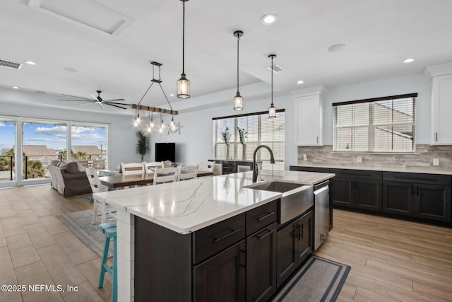 548 Sea Island Dr, Fernandina Beach, FL 32034 - kitchen with a sink, white cabinetry, a breakfast bar area, open floor plan, and recessed lighting