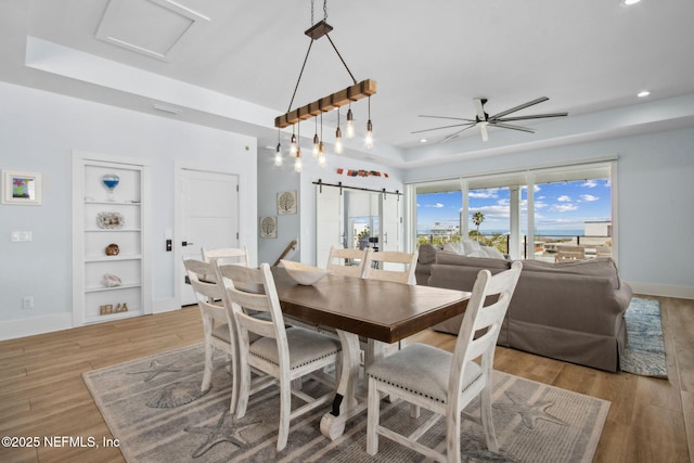 548 Sea Island Dr, Fernandina Beach, FL 32034 - dining area with ceiling fan, recessed lighting, light wood finished floors, a raised ceiling, and baseboards
