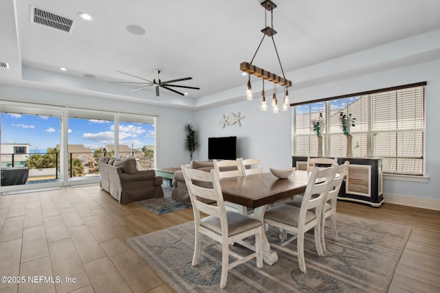 548 Sea Island Dr, Fernandina Beach, FL 32034 - dining room with a tray ceiling, wood finished floors, ceiling fan, recessed lighting, and baseboards