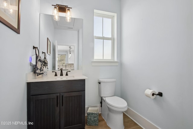 548 Sea Island Dr, Fernandina Beach, FL 32034 - bathroom with wood finished floors, toilet, baseboards, and vanity